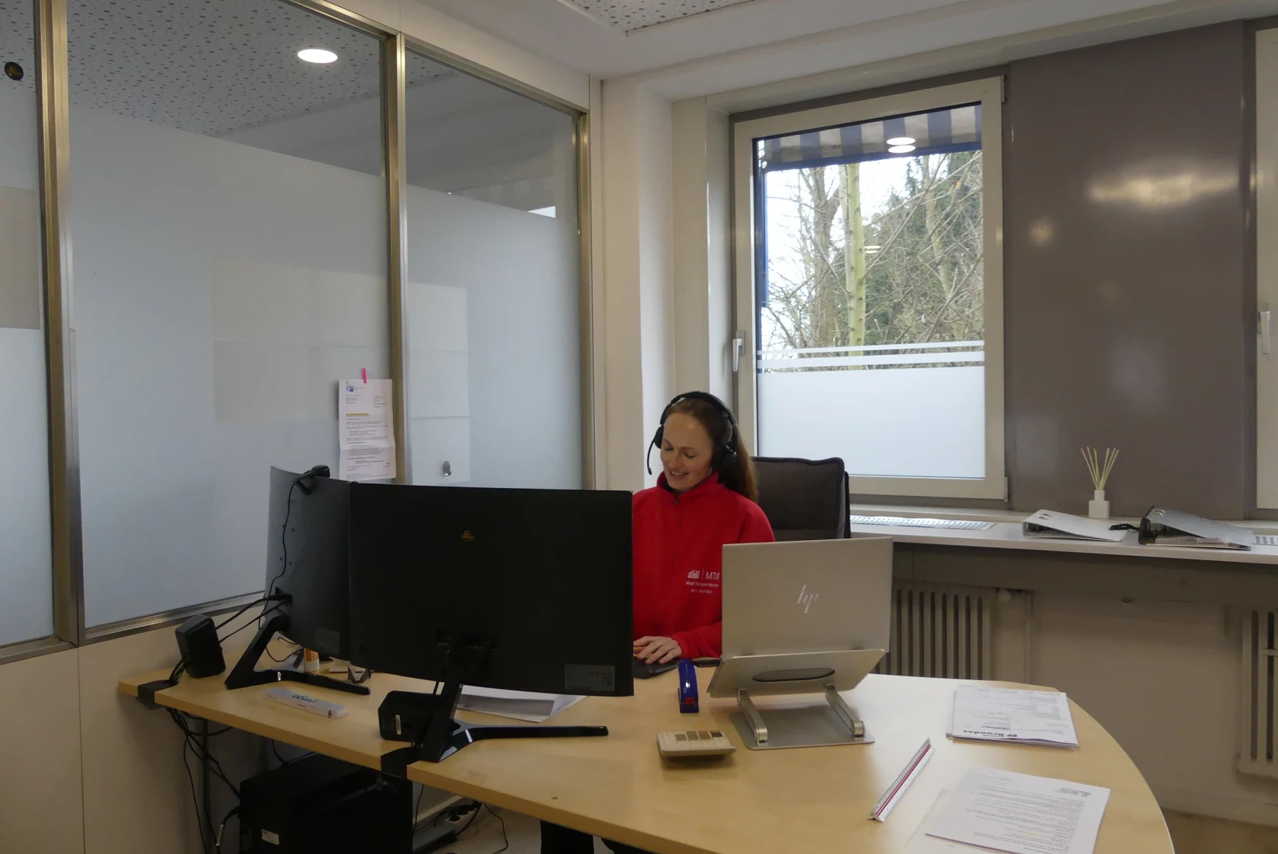 MTM Mitarbeiterin im Büro mit Headset.