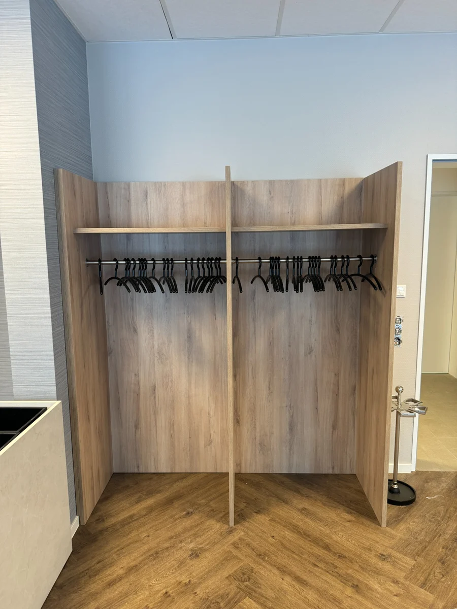 Montierte Garderobe mit Kleiderstangen.
