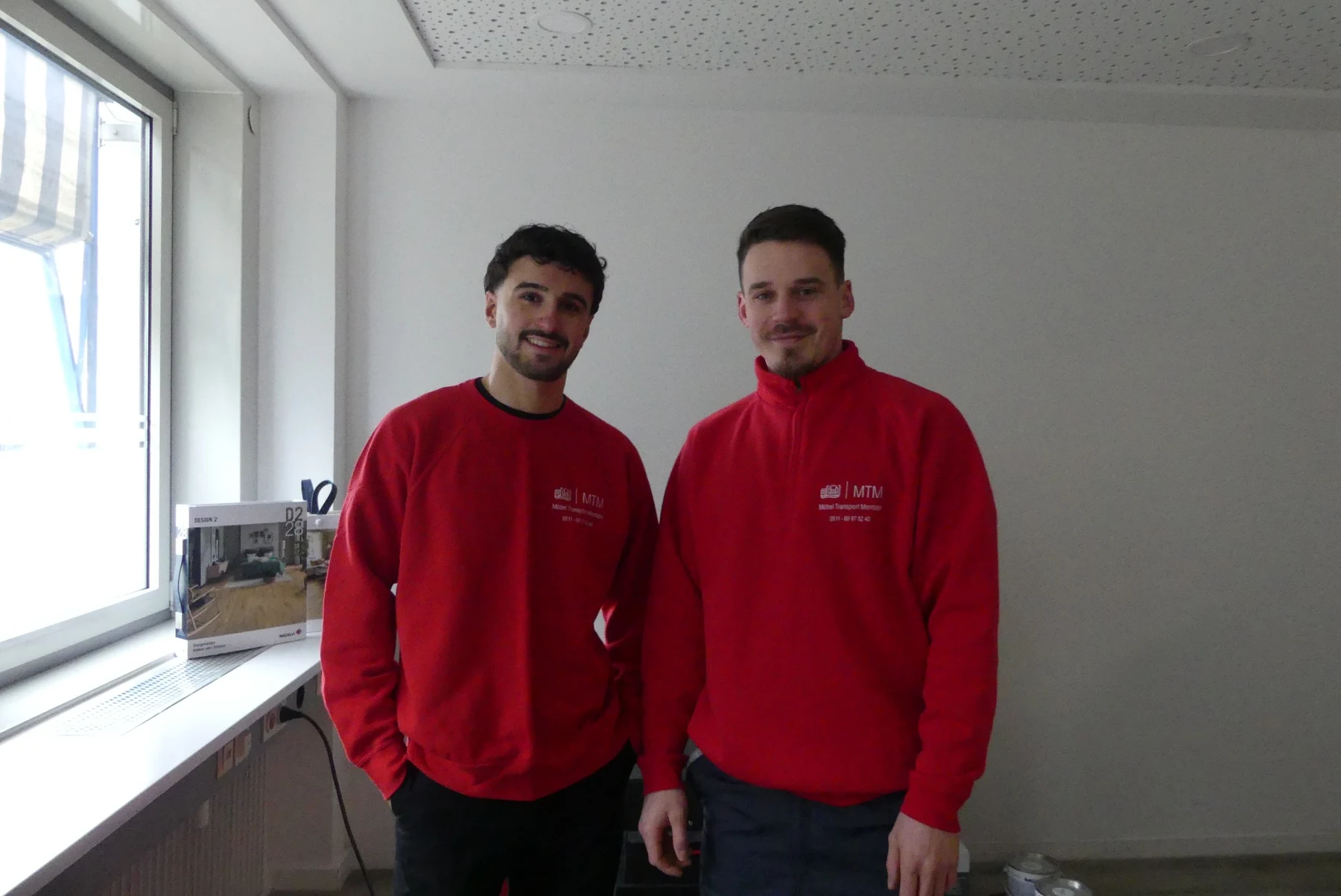 Zwei MTM Mitarbeiter in Firmenkleidung.
